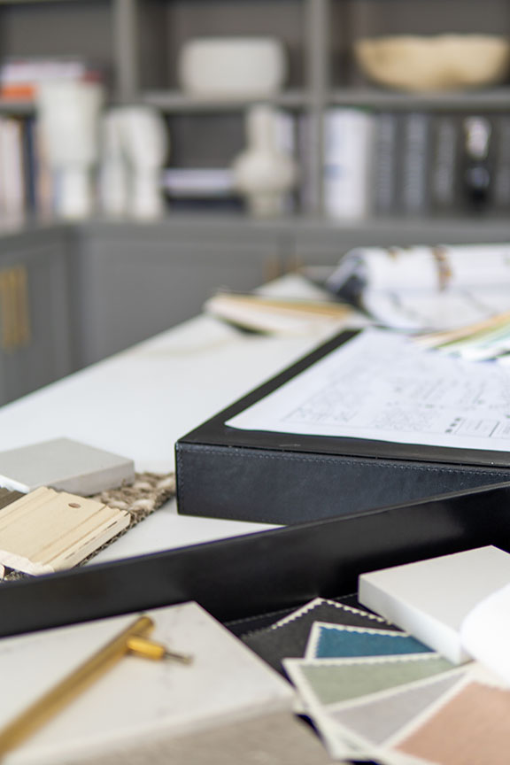 Interior designer's working table, an architectural plan of the house, a color palette.